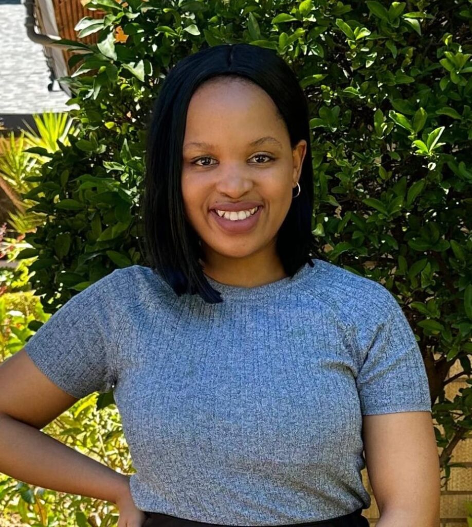 Black woman smiling with a tree in the background